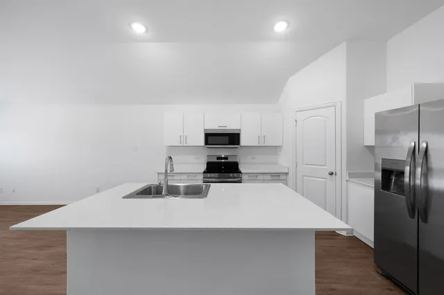 a kitchen with a refrigerator and a stove top oven