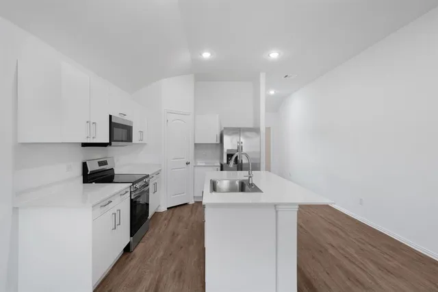 a kitchen with a sink a stove and cabinets