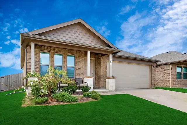 a front view of a house with a garden and plants