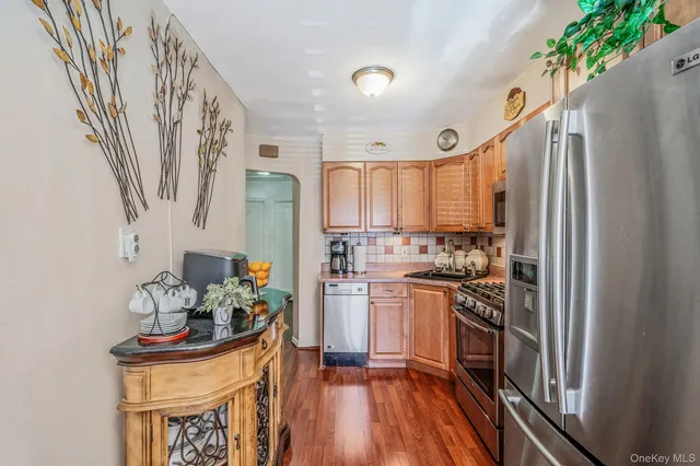 a kitchen with stainless steel appliances a stove a sink and a refrigerator