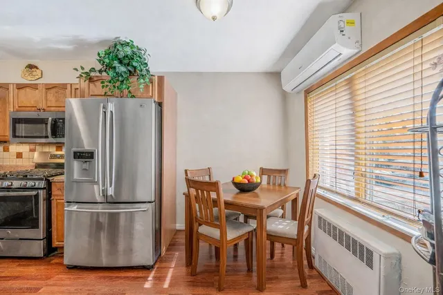 a kitchen with stainless steel appliances wooden floor and large window