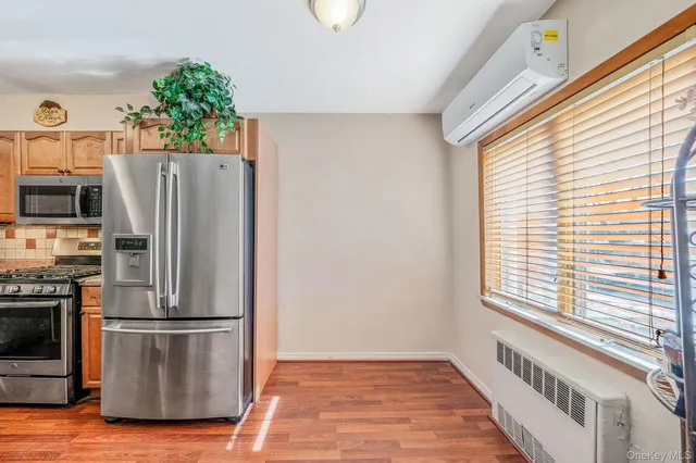 a kitchen with stainless steel appliances a refrigerator and a wooden floor