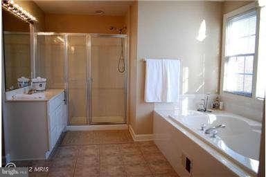 9129 Travener Circle Frederick, MD 21704 - Photo 17 of 28 a bathroom with a tub a sink and a large mirror