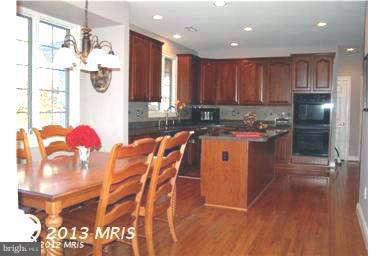 9129 Travener Circle Frederick, MD 21704 - Photo 7 of 28 a kitchen with stainless steel appliances granite countertop a sink cabinets and wooden floor