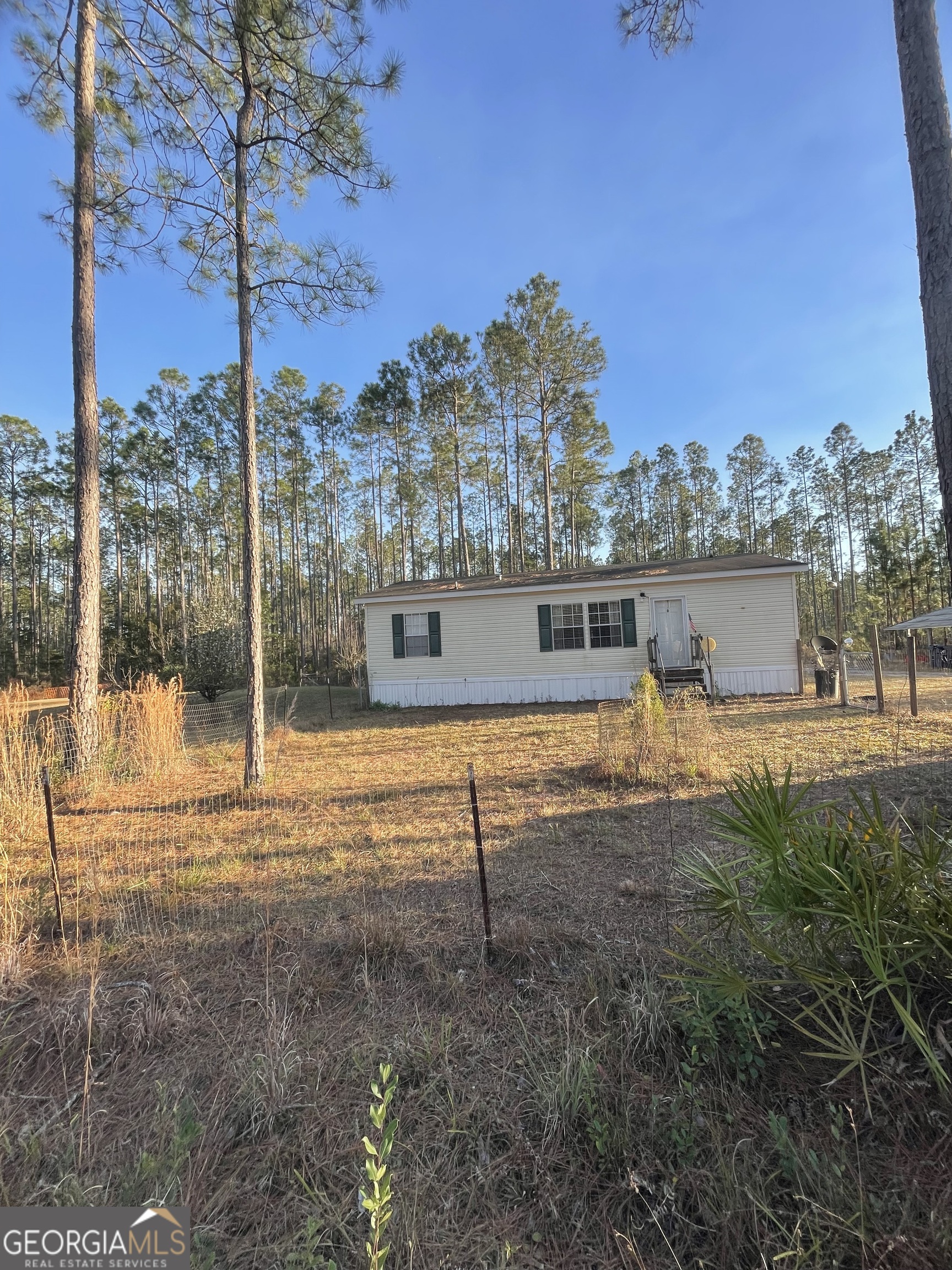 695 Sam Houston Road Folkston, GA 31537 - Photo 1 of 1 a view of a yard with a house in the background