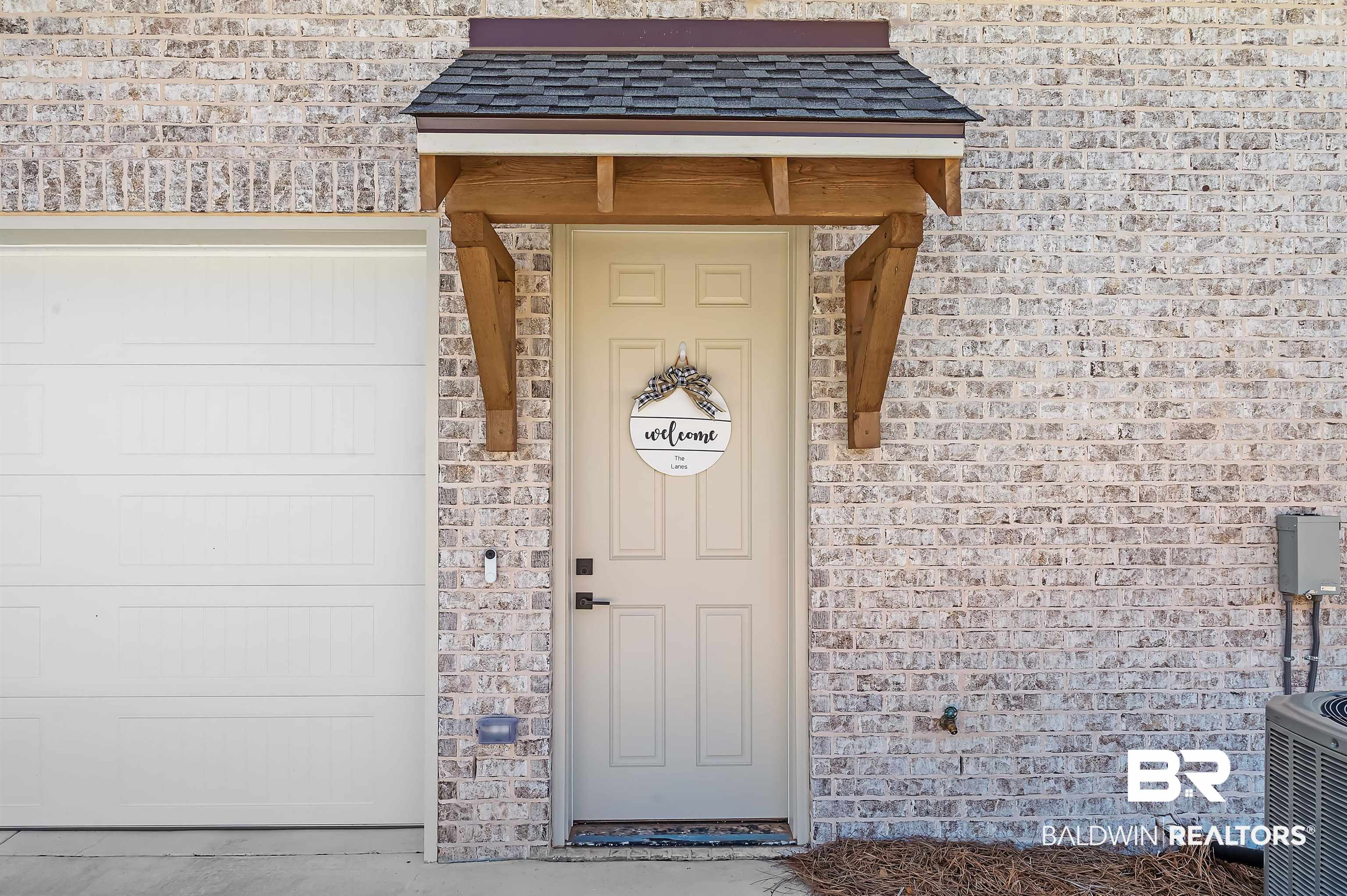 9144 Harvest Ridge Fairhope, AL 36532 - Photo 11 of 58 Doorway to property featuring central air condition unit, a shingled roof, and a garage