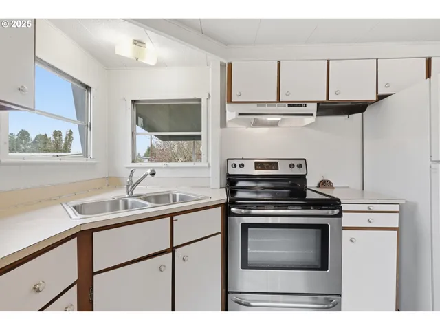 a kitchen with granite countertop white cabinets and white appliances