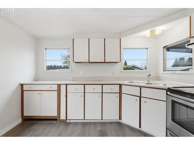 a kitchen with stainless steel appliances a stove a microwave and a chandelier