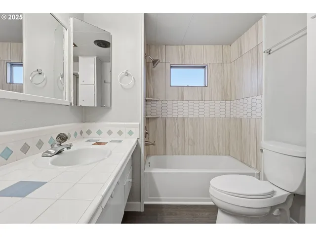 a bathroom with a tub a sink and mirror