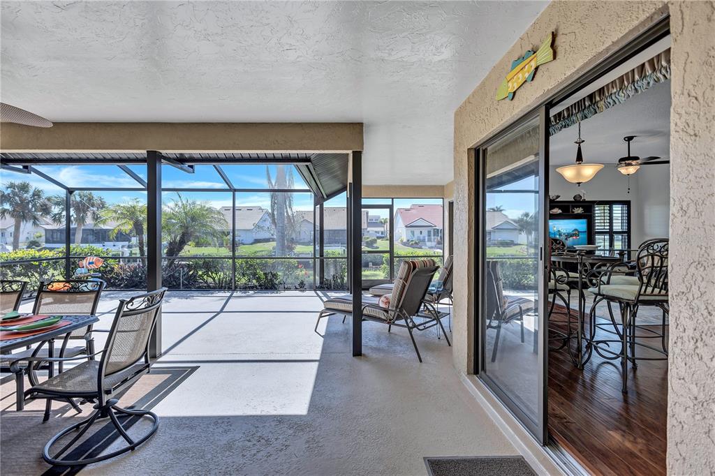 104 Inlets Boulevard, Unit 104 Nokomis, FL 34275 - Photo 25 of 66 a living room with furniture a floor to ceiling window and potted plants