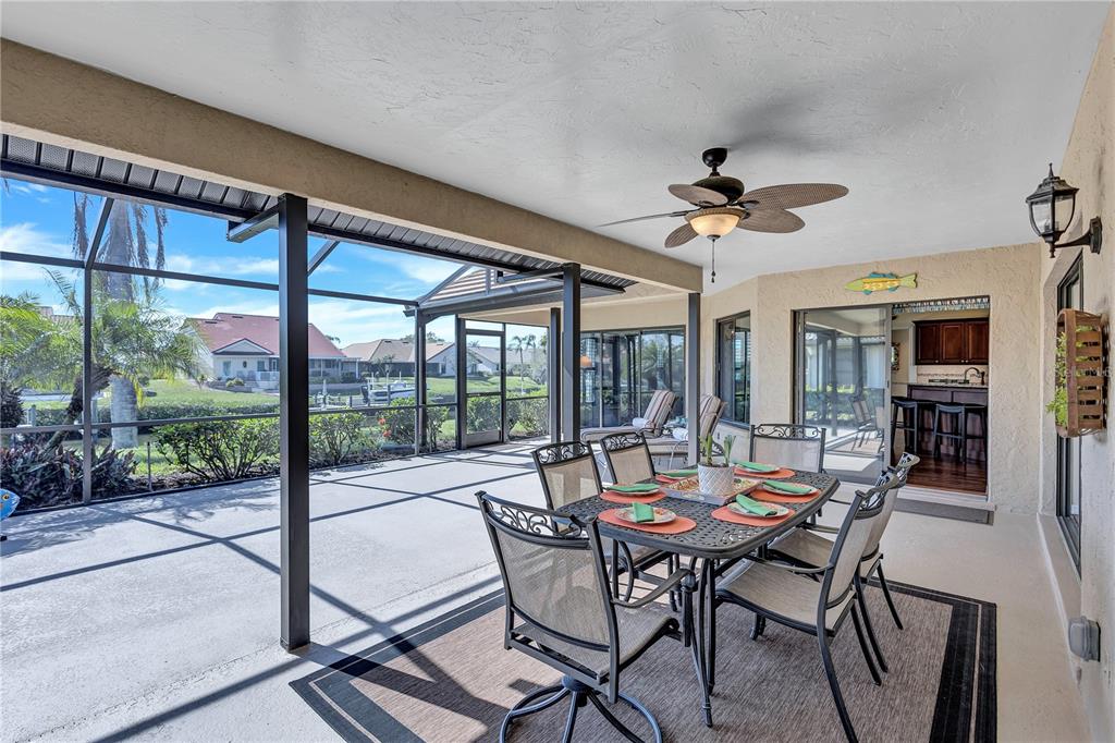 104 Inlets Boulevard, Unit 104 Nokomis, FL 34275 - Photo 26 of 66 a view of a dining room with furniture large windows and a chandelier