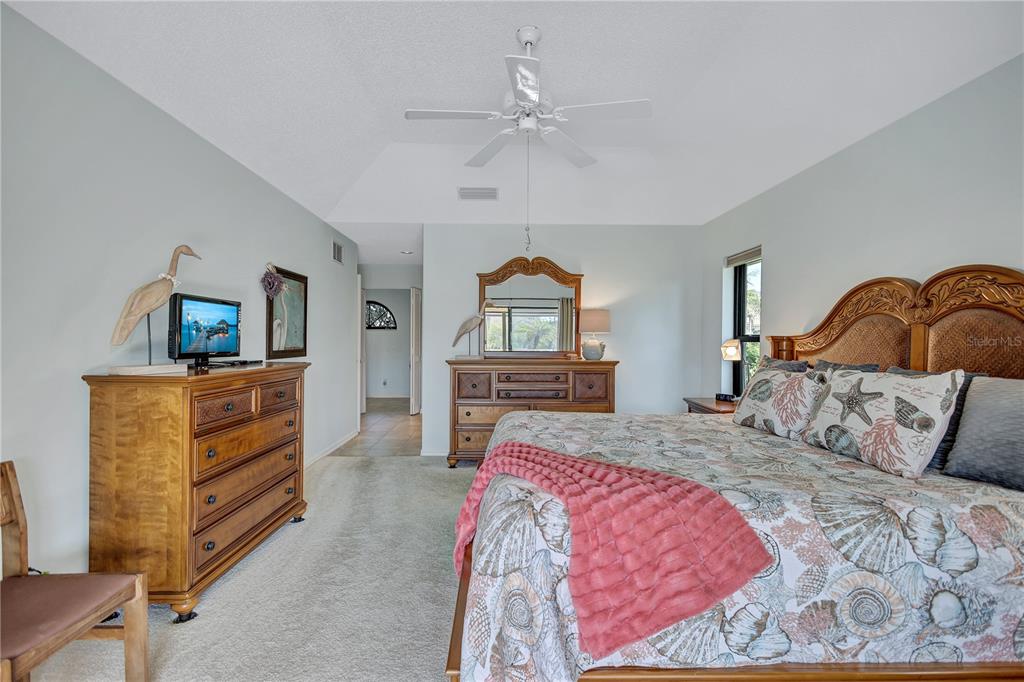 104 Inlets Boulevard, Unit 104 Nokomis, FL 34275 - Photo 32 of 66 a bedroom with a bed and a dresser in it