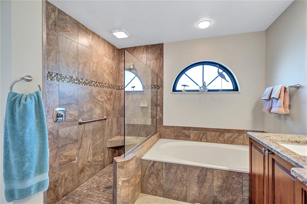 104 Inlets Boulevard, Unit 104 Nokomis, FL 34275 - Photo 34 of 66 a bathroom with a tub sink and mirror