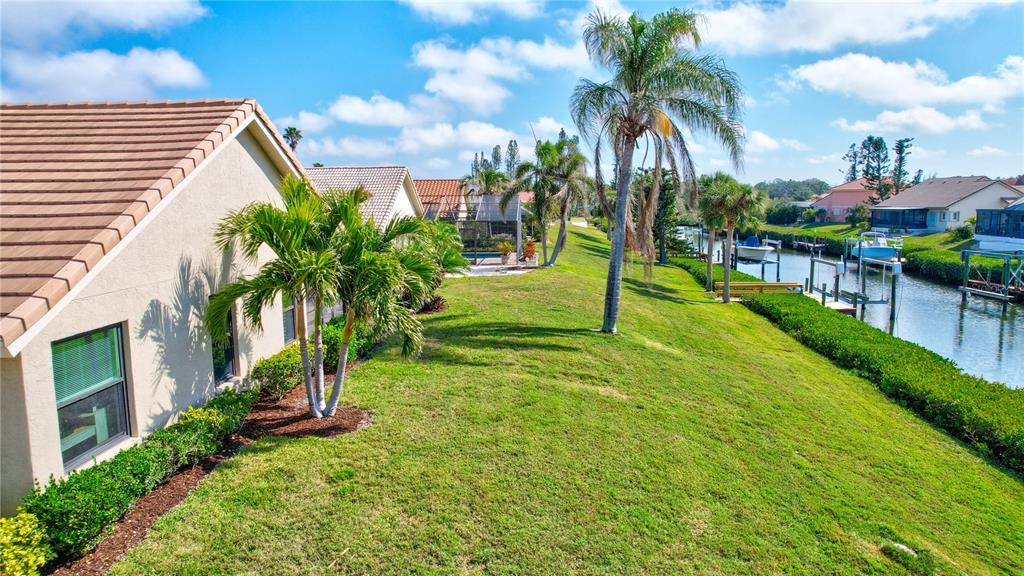 104 Inlets Boulevard, Unit 104 Nokomis, FL 34275 - Photo 61 of 66 a view of a house with a yard and palm trees