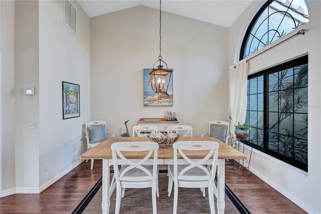 104 Inlets Boulevard, Unit 104 Nokomis, FL 34275 - Photo 9 of 66 a dining room with furniture a chandelier and wooden floor