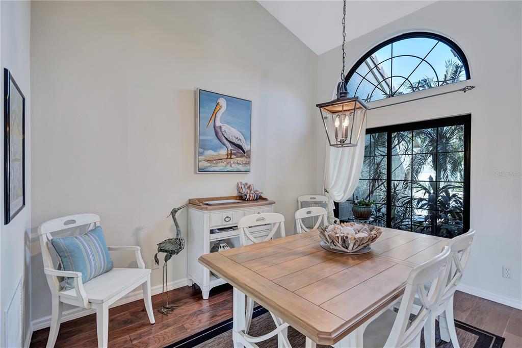 104 Inlets Boulevard, Unit 104 Nokomis, FL 34275 - Photo 10 of 66 a view of a dining room with furniture window and wooden floor