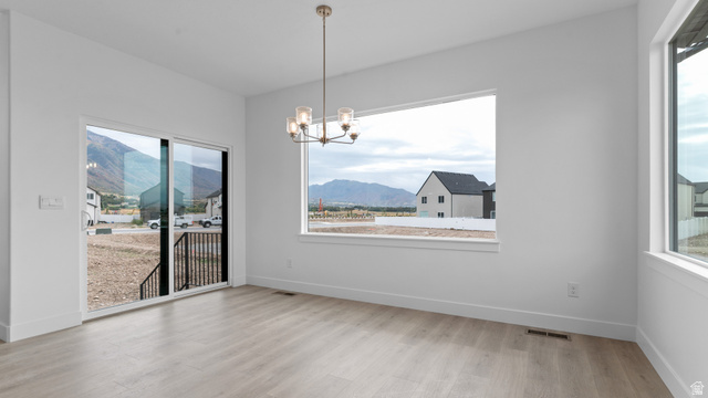 4170 North 560th West, Unit 6 Tooele, UT 84074 - Photo 5 of 20 Open living space featuring wood-finish flooring, a contemporary chandelier, and white wall finishes