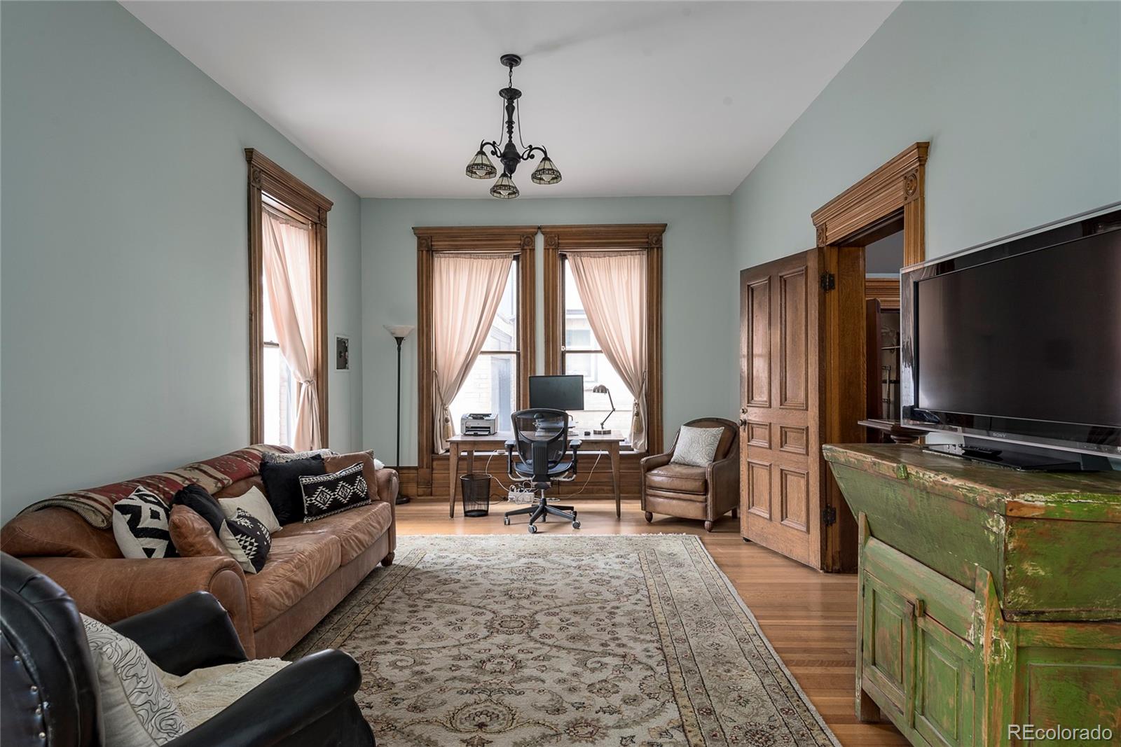 131 Sherman Street Denver, CO 80203 - Photo 13 of 36 a living room with furniture and a flat screen tv