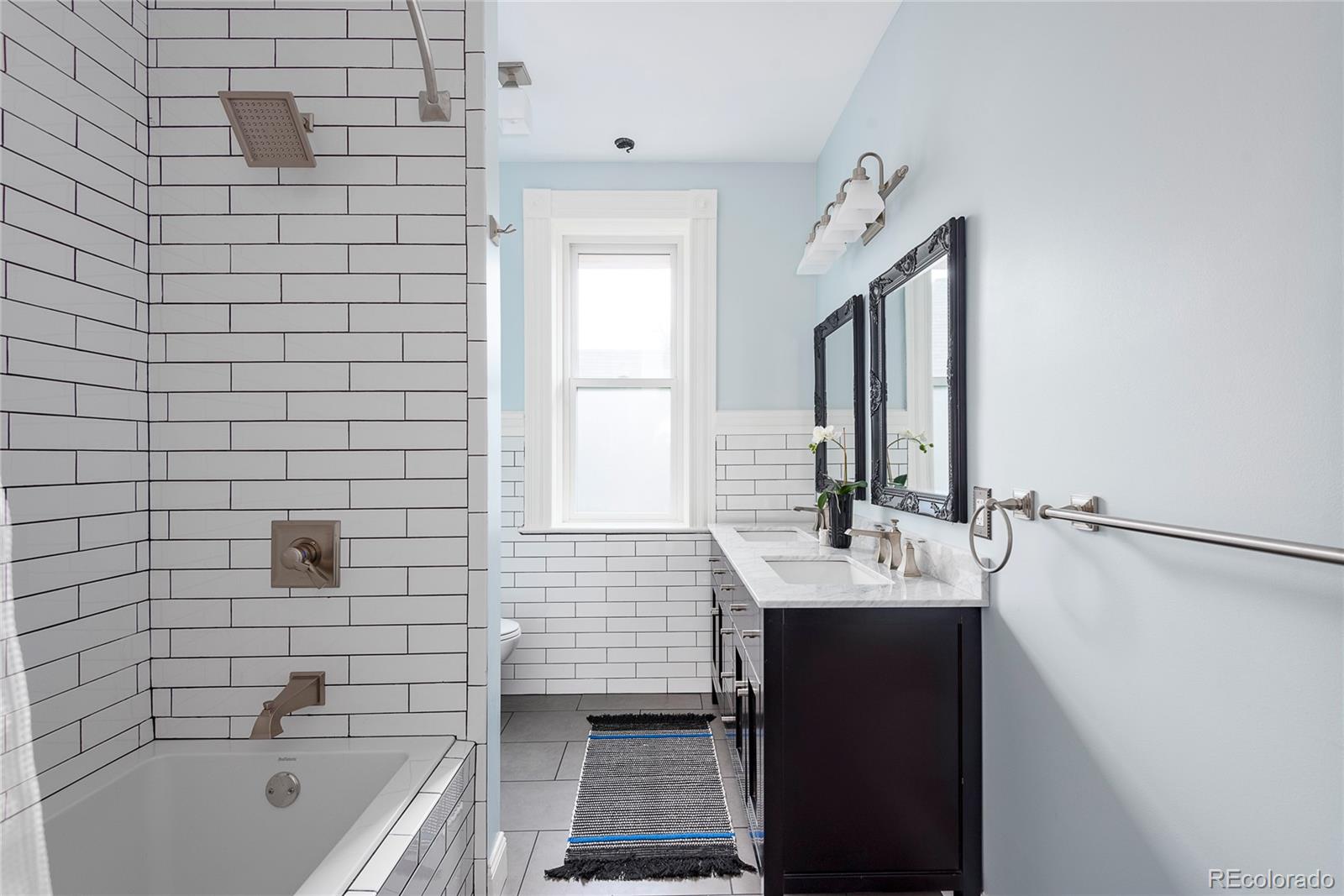 131 Sherman Street Denver, CO 80203 - Photo 25 of 36 a bathroom with a sink a bathtub and a mirror