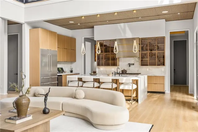 a kitchen with stainless steel appliances granite countertop a sink a stove and a wooden floors