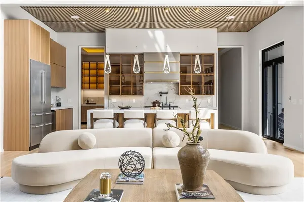 a large white kitchen with cabinets a sink a window and a couch