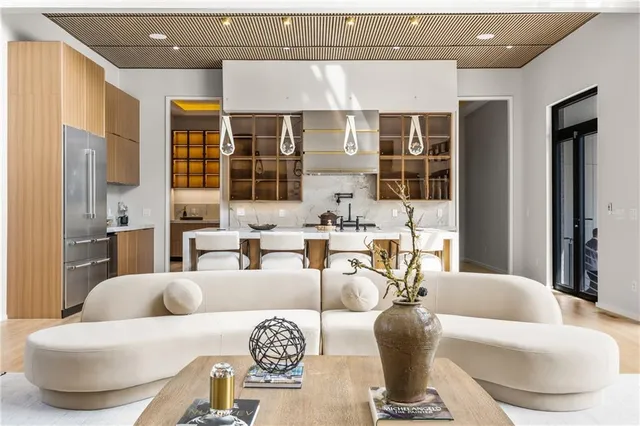 a large white kitchen with cabinets a sink a window and a couch