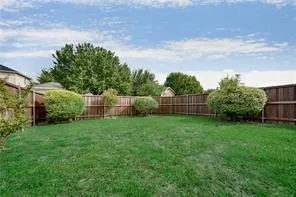 a view of a backyard with plants and large trees