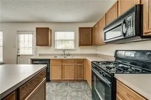 a kitchen with stainless steel appliances a sink stove and cabinets