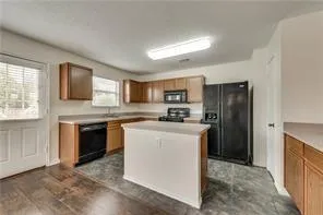 a kitchen with stainless steel appliances granite countertop a refrigerator sink and stove