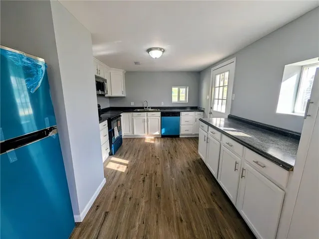a view of a kitchen with a sink wooden floor and staircase