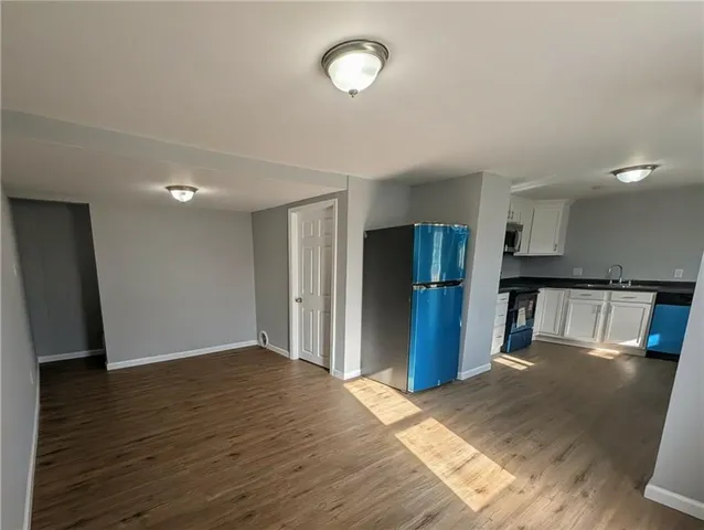 a view of a kitchen with wooden floor and a refrigerator