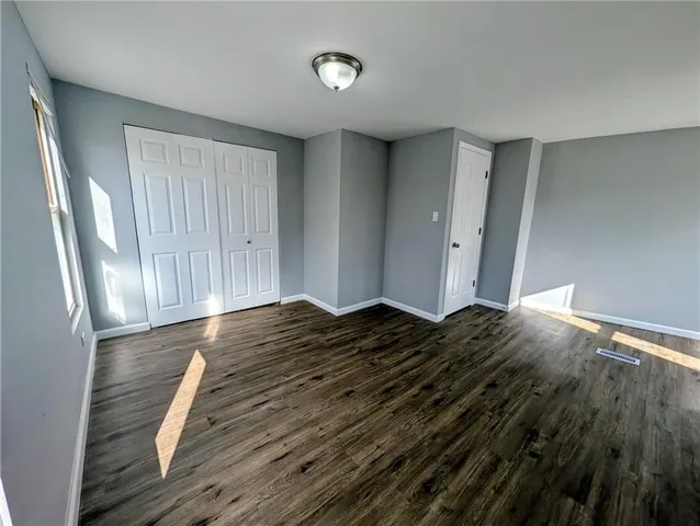 a view of a bedroom with wooden floor