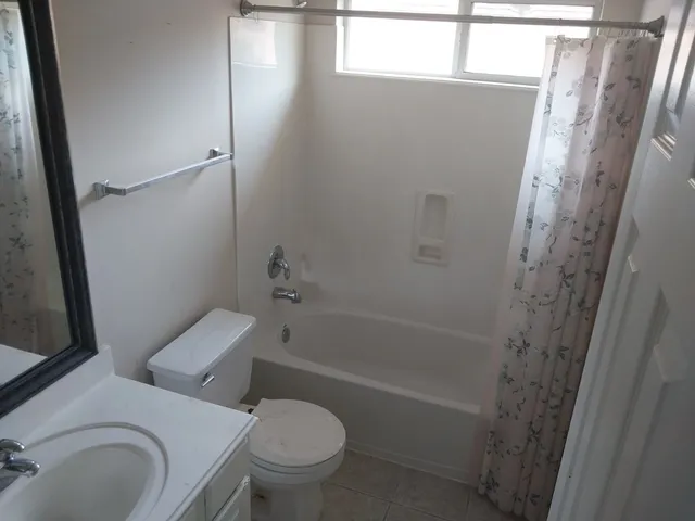 a white toilet sitting next to a white cabinet
