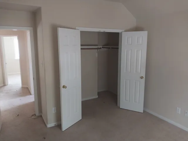an empty room with closet and a bathroom