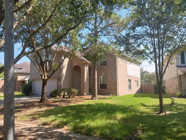 a view of a house with yard and tree s