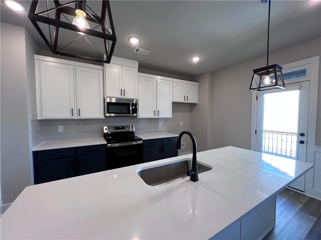 23 Rock Pk Way, Unit 26 Tucker, GA 30084 - Photo 12 of 28 a kitchen with granite countertop a stove a sink and a microwave