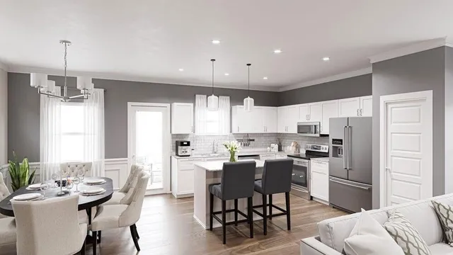 a kitchen with stainless steel appliances kitchen island granite countertop a dining table chairs refrigerator and sink