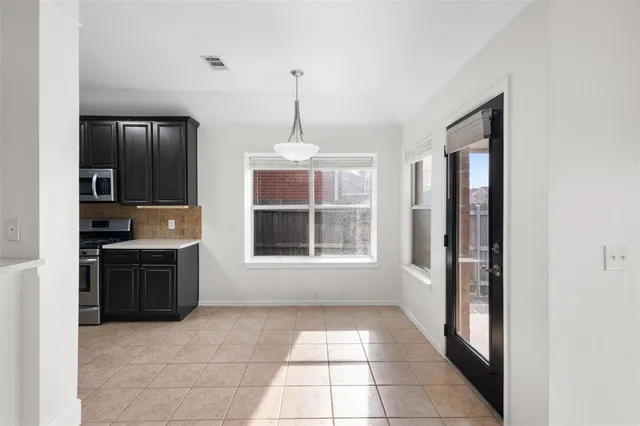 a view of an empty room with a window and chandelier
