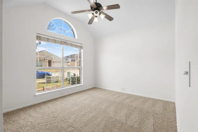 an empty room with windows and fan
