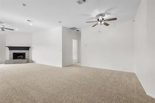 a view of a livingroom with a ceiling fan and fireplace