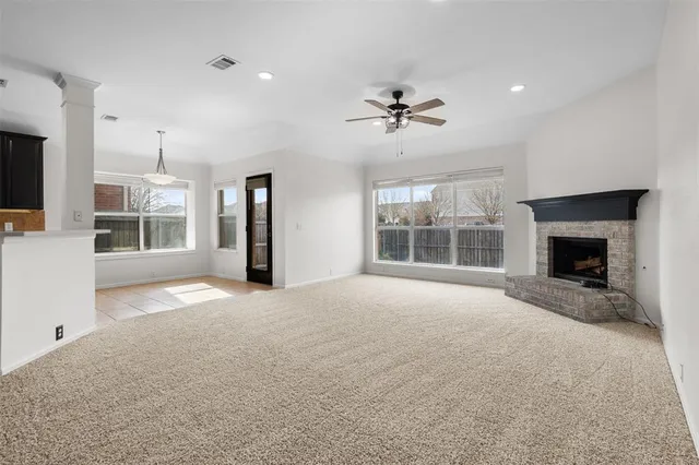 a view of an empty room with a fireplace and a window