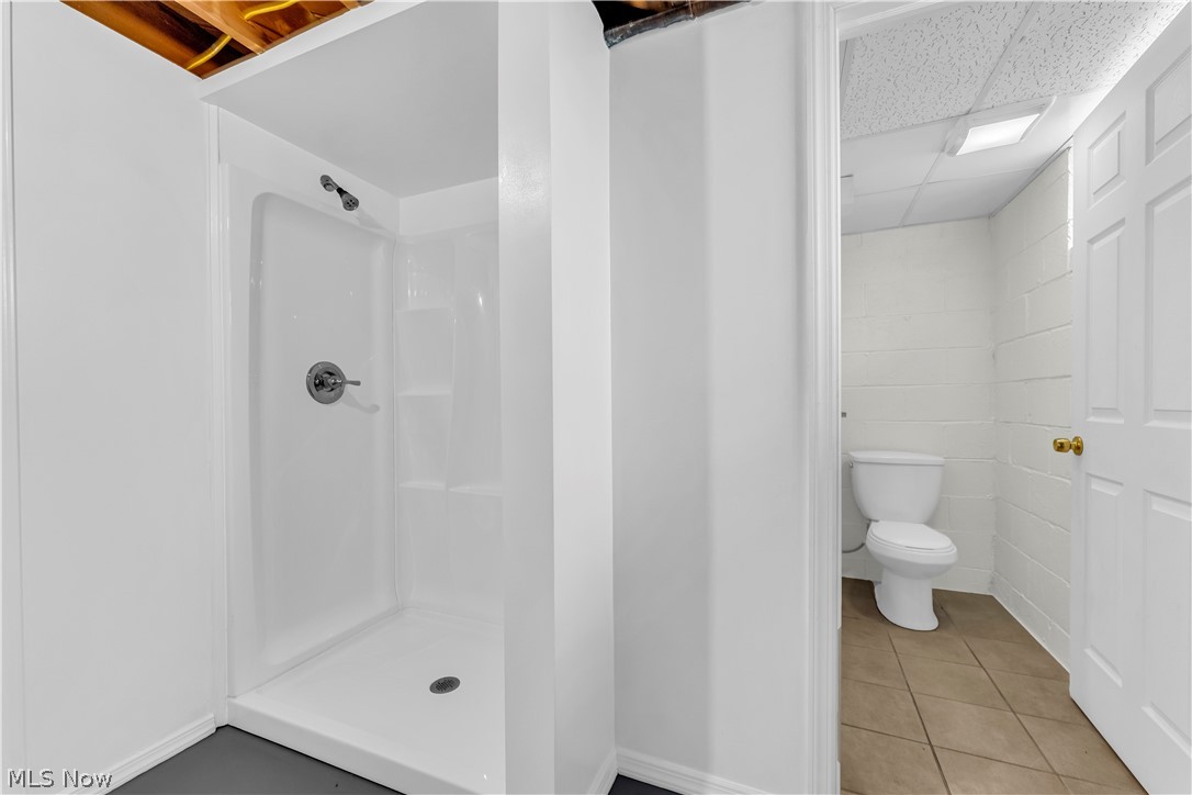 9716 Alexander Road Cleveland, OH 44125 - Photo 21 of 30 Full bathroom with a paneled ceiling, a stall shower, and light tile patterned flooring