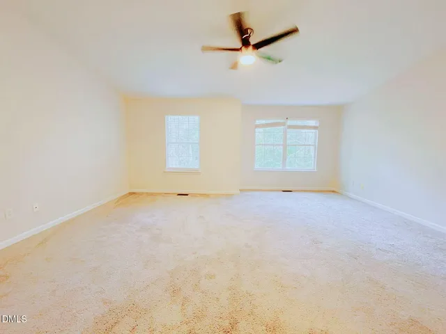 an empty room with a empty space and a ceiling fan