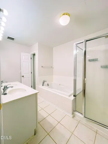 a spacious bathroom with a tub shower and sink