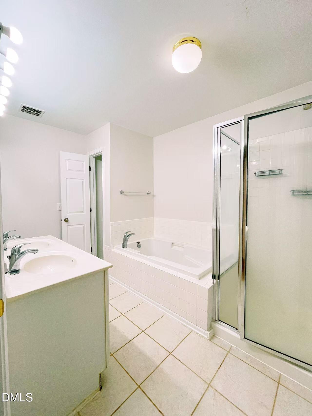3040 Barrymore Street, Unit 108 Raleigh, NC 27603 - Photo 13 of 13 a spacious bathroom with a tub shower and sink