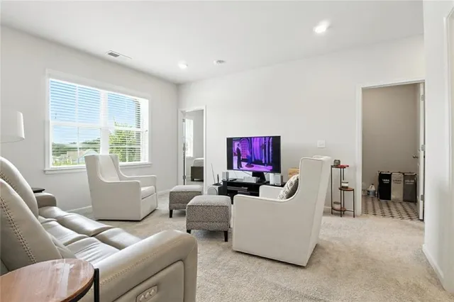 a living room with furniture a large window and a flat screen tv