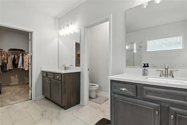 a bathroom with a double vanity sink and a toilet