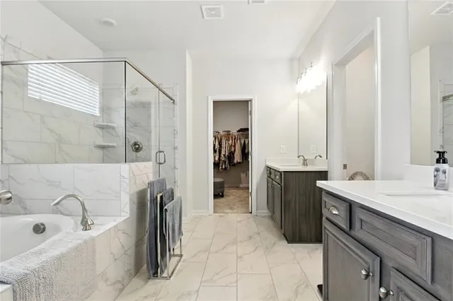 a spacious bathroom with a tub sink and mirror