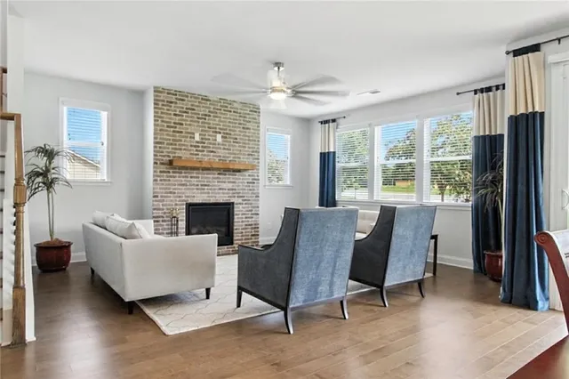 a living room with furniture a large window and a fireplace
