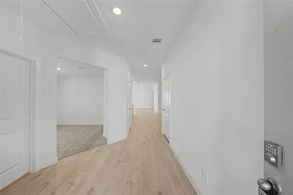 a view of a hallway with wooden floor